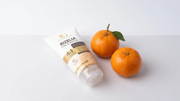 Rizelia rice water face wash beside two fresh kinnow mandarins